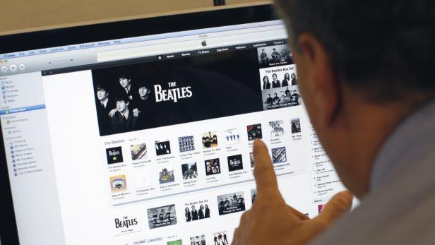 A man poses as he looks at music from the legendary band The Beatles on Apple&#039;s itunes music store website seen on an imac computer in New York, November 16, 2010. Apple inc. announced Tuesday that The Beatles&#039; 13 albums would be available for downloading through the itunes music store, the world&#039;s number one digital music retailer. REUTERS/Mike Segar (UNITED STATES - Tags: ENTERTAINMENT BUSINESS)