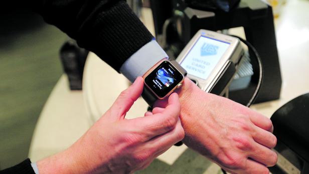 FILE PHOTO: A man uses an Apple Watch to demonstrate the mobile payment service Apple Pay at a cafe in Moscow, Russia