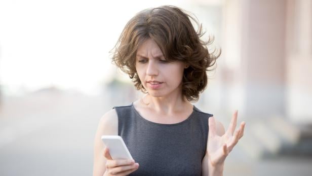 Young business woman irritated with her phone