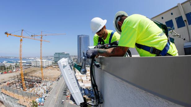 FILE PHOTO: Telecommunication workers Chris Viens and Guy Glover install a new 5G antenna system for AT&T's 5G wireless network in downtown San Diego