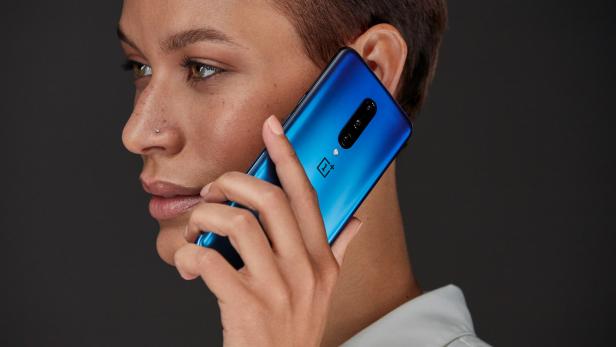 Eine Frau telefoniert mit einem blauen OnePlus-Smartphone.