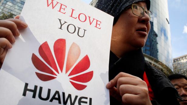 FILE PHOTO: Lisa Duan, a visitor from China, holds a sign in support of Huawei outside of the B.C. Supreme Court bail hearing of Huawei CFO Meng Wanzhou, who is being held on an extradition warrant in Vancouver