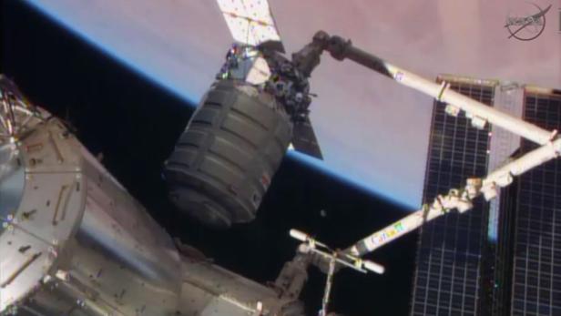 Der Roboterarm Canadarm2 schiebt den Cygnus-Transporter an die Ladeluke des Harmony-Moduls der ISS.