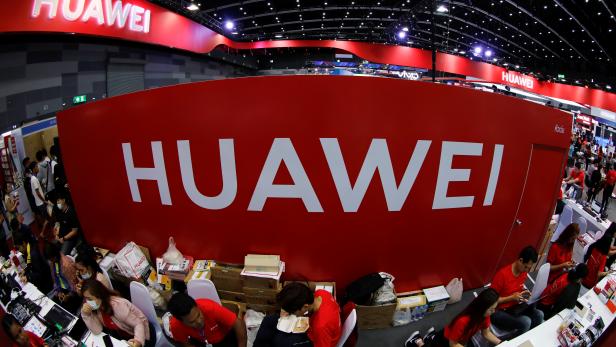 Workers sit at the Huawei stand at the Mobile Expo in Bangkok
