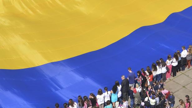 Ukrainer halten die Nationalflagge hoch in Chernivtsi.