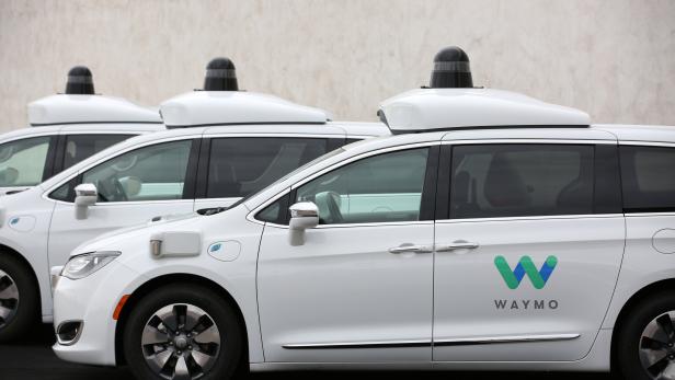 Three of the fleet of 600 Waymo Chrysler Pacifica Hybrid self-driving vehicles are parked and diaplayed during a demonstration in Chandler, Arizona