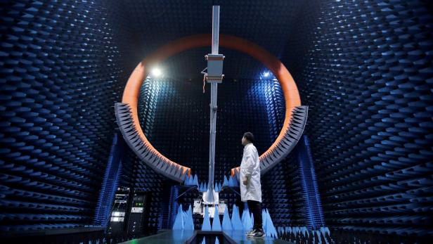 FILE PHOTO: An engineer stands under a base station antenna of 5G in Huawei's SG178 multi-probe spherical near-field testing system at its Songshan Lake Manufacturing Center in Dongguan