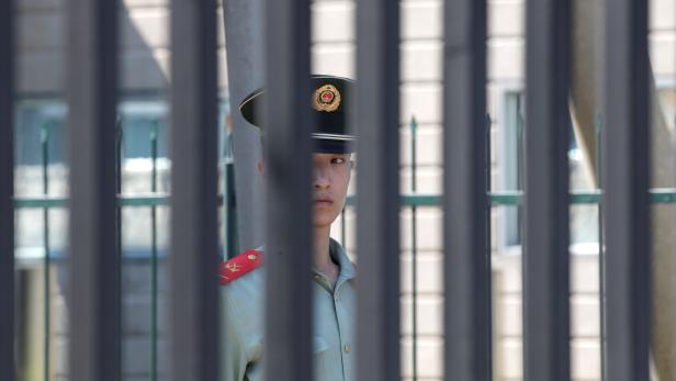 A paramilitary police officer stands guard behind a fence after a blast outside the U.S. embassy in Beijing