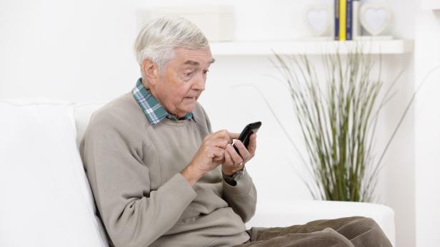 Senior Man Reading A Shocking Message On His Smart Phone