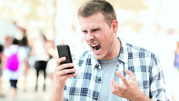 Angry man holding crashed phone