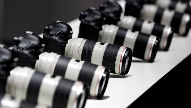 FILE PHOTO: Canon cameras with lenses are pictured at the stand of Japanese camera maker Canon on the press day of the world's largest fair for imaging in Cologne