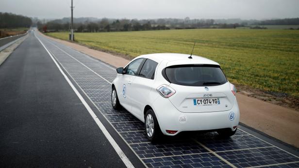An automobile drives on a solar panel road during its inauguration in Tourouvre