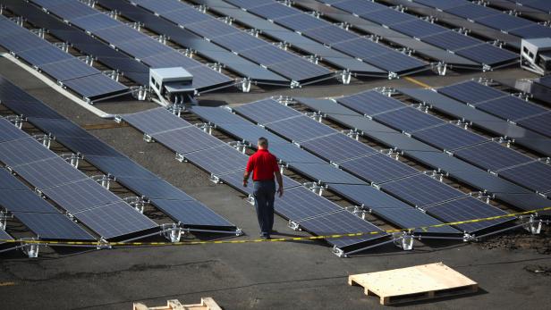 A man walks between solar panels set up by Tesla, at the  San Juan Children's Hospital, after the island was hit by Hurricane Maria in September, in San Juan