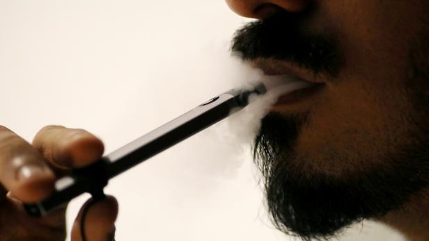 Ali Mansoor, an Emirati vape enthusiast, poses while smoking an e-cigarette at a cafe in Dubai