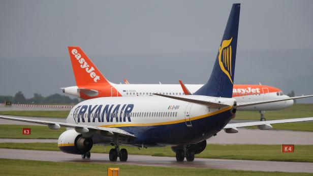 FILE PHOTO: A Ryanair aircraft taxis behind an easyJet aircraft at Manchester Airport