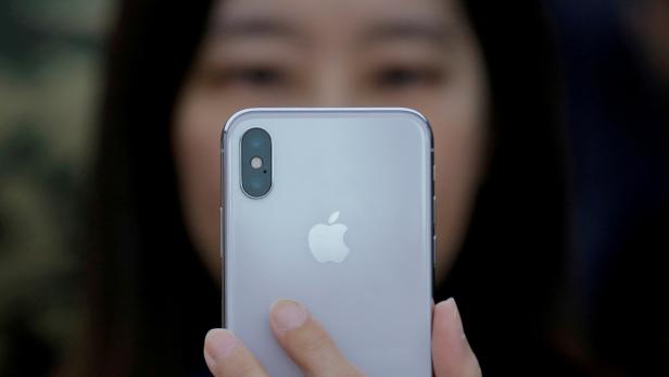 FILE PHOTO: An attendee uses a new iPhone X during a presentation for the media in Beijing
