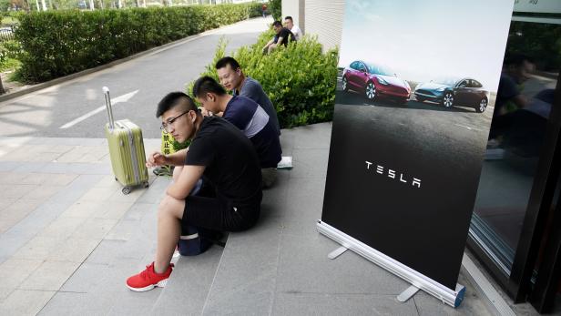 FILE PHOTO: People sit as they wait for job interviews at a job fair for Tesla Gigafactory in Shanghai