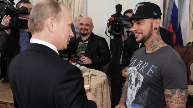 FILE PHOTO: Russian PM Putin talks to rapper Timati during a meeting with his supporters in Moscow
