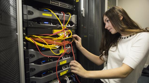 IT worker in server room patching cables