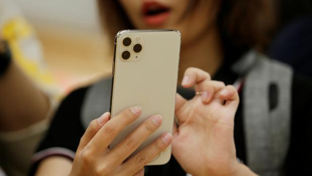 A woman holds an iPhone 11 Pro Max after it went on sale at the Apple Store in Beijing