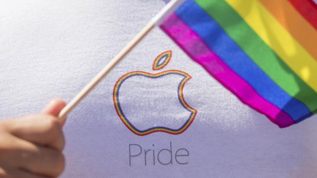 An Apple employee waves a rainbow flag before the San Francisco Gay Pride Festival in California