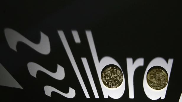 FILE PHOTO: FILE PHOTO: FILE PHOTO: Shadow of a 3D-printed Facebook Libra cryptocurrency logo is seen near cryptocurrency representation in this illustration taken