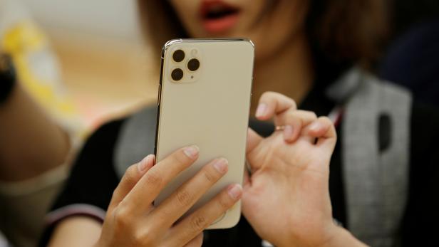 A woman holds an iPhone 11 Pro Max after it went on sale at the Apple Store in Beijing