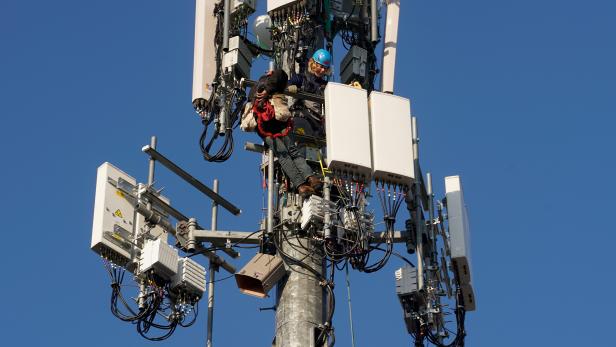 A contract crew from Verizon installs 5G equipment on a tower in Orem