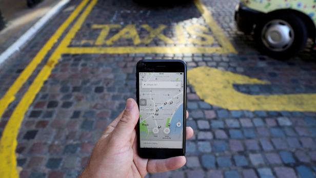 FILE PHOTO: A photo illustration shows the Uber app and a black cab in London,