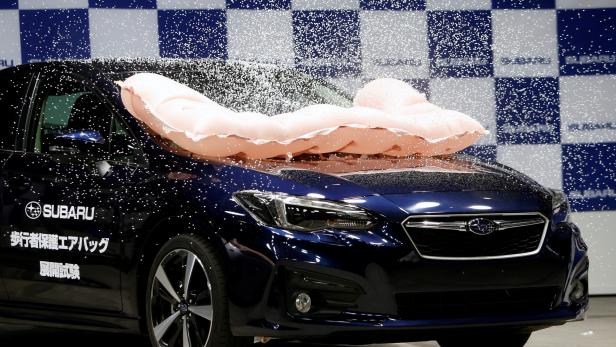 External airbag splashes mock snow, covering the surface of Subaru Impreza G4, as it is triggered during collision test demonstration, at its factory in Ota