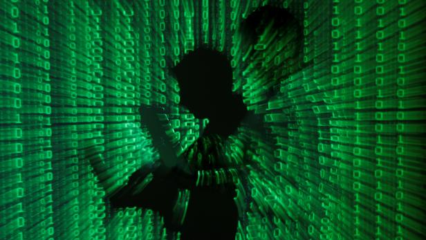 FILE PHOTO: An illustration picture shows projection of binary code on man holding aptop computer in Warsaw FILE PHOTO: An illustration picture shows projection of binary code on man holding aptop computer in Warsaw