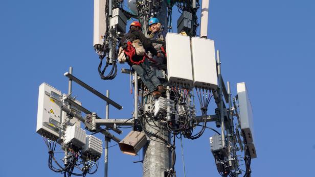 A crew from Verizon installs 5G equipment on a tower in Orem