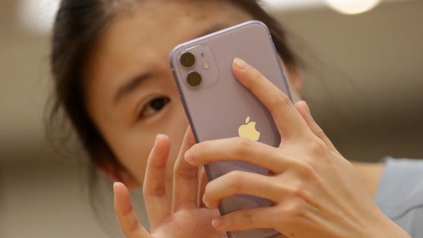 FILE PHOTO: A customer tests Apple's iPhone 11 after it went on sale at the Apple Store in Beijing