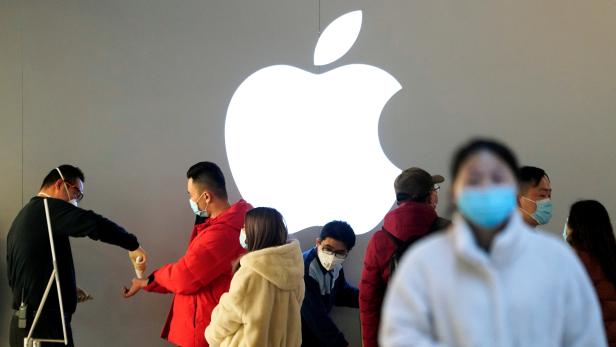 FILE PHOTO: People wearing protective masks wait for checking their temperature in an Apple Store, in Shanghai
