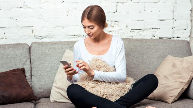 Woman with a mobile phone on couch