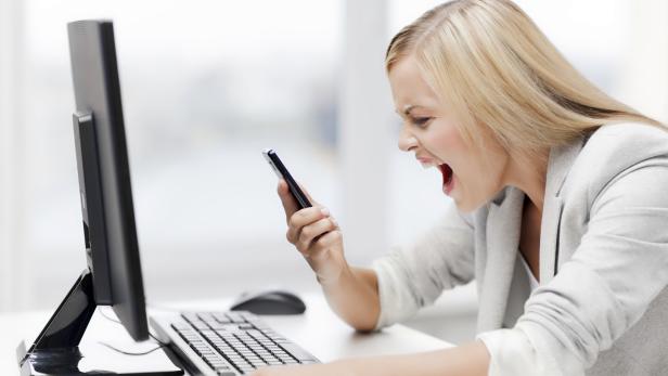 angry woman with smart phone and computer screaming curses