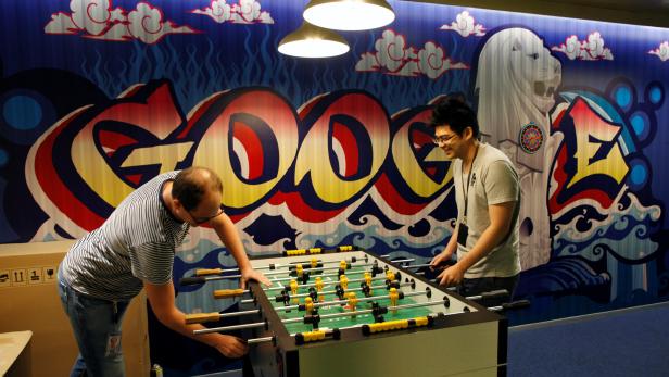 FILE PHOTO: Google's communications manager Moroney plays table soccer with a Google employee at a recreational area of their Singapore office