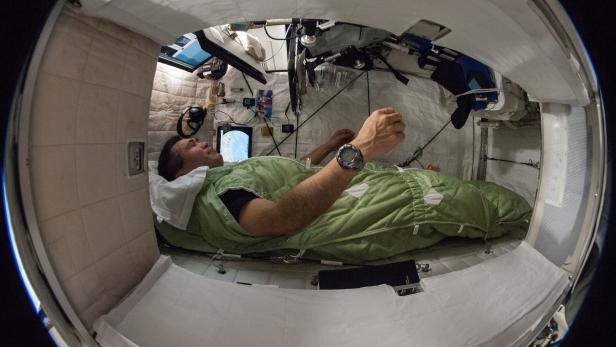Der japanische Raumfahrer Koichi Wakata in seiner Schlafkabine an Bord der ISS