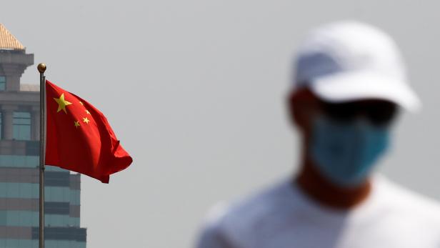 A man walks near the Chinese national flag in Beijing