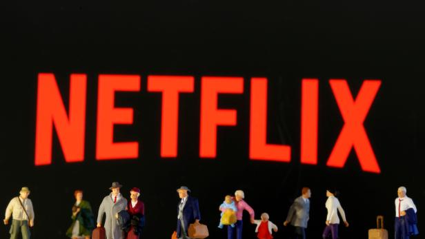 FILE PHOTO: Small toy figures are seen in front of diplayed Netflix logo