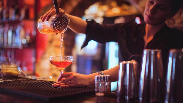 Young female bartender pouring cocktails in a cocktail bar Young female bartender pouring cocktails in a cocktail bar