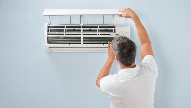 Man Cleaning Air Conditioning System