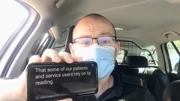 Der britische Rettungssanitäter Danny Hughes führt vor, wie man trotz Maske mit gehörlosen Patienten sprechen kann