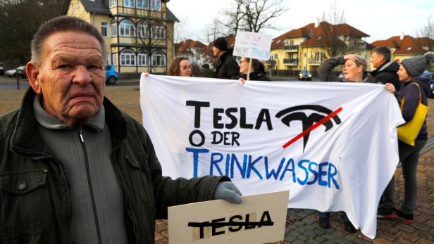 FILE PHOTO: Demonstrators hold anti-Tesla posters during a protest against plans by U.S. electric vehicle pioneer Tesla to build its first European factory and design center near Berli