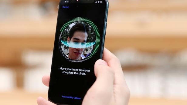 A customer sets up his iPhone X Face ID during its launch at the Apple store in Singapore