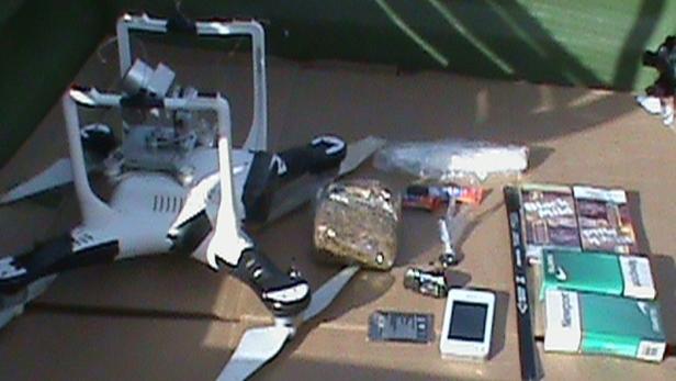 A drone carrying cellphones, drugs, hacksaw blades and other material that dangled in a bundle from a fishing line