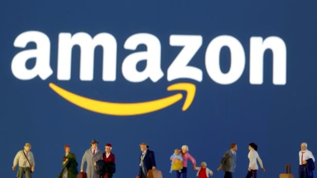 FILE PHOTO: FILE PHOTO: Small toy figures are seen in front of diplayed Amazon logo