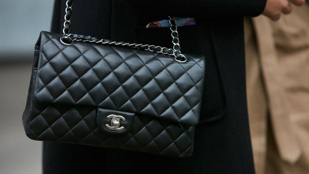 Woman with black Chanel leather bag with silver chain