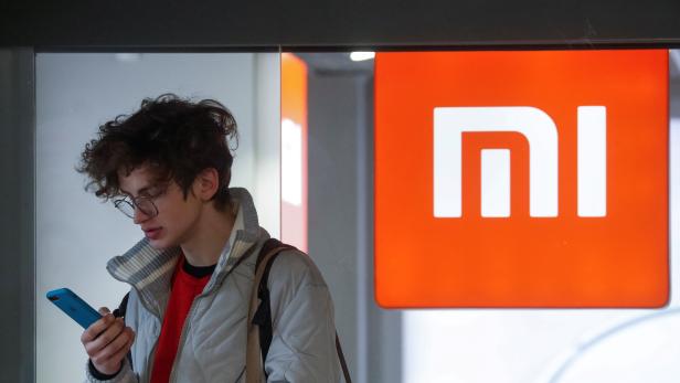 FILE PHOTO: A man uses his smartphone next to the Xiaomi brand's store in central Kiev