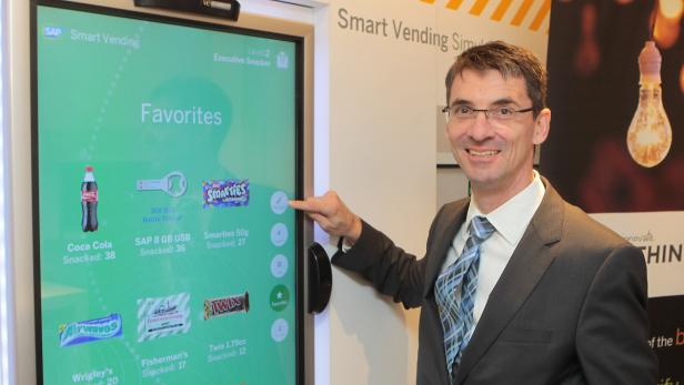Vorstand Bernd Leukert mit einem sich selbst organisierenden Snack-Automaten im Big-Data-Truck von SAP